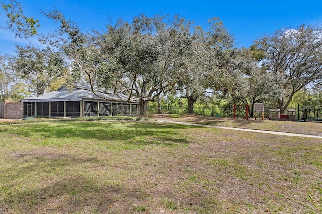 view of yard with a sunroom and fence