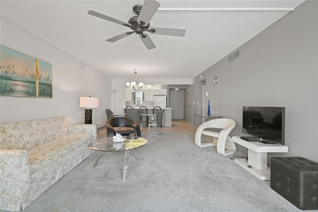 living room featuring light carpet, visible vents, a textured ceiling, and ceiling fan with notable chandelier