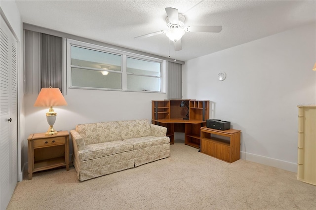 sitting room with carpet, ceiling fan, a textured ceiling, and baseboards