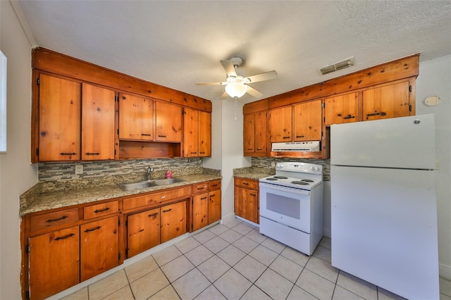 kitchen with visible vents, a sink, white appliances, exhaust hood, and brown cabinetry