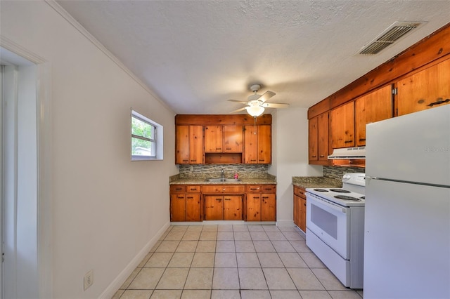 kitchen with under cabinet range hood, visible vents, brown cabinets, and white appliances