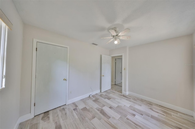 unfurnished room with visible vents, baseboards, light wood finished floors, and ceiling fan