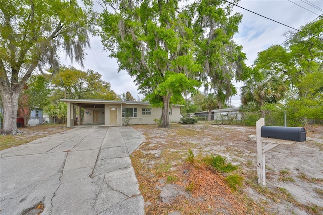 single story home with an attached carport, concrete driveway, and fence