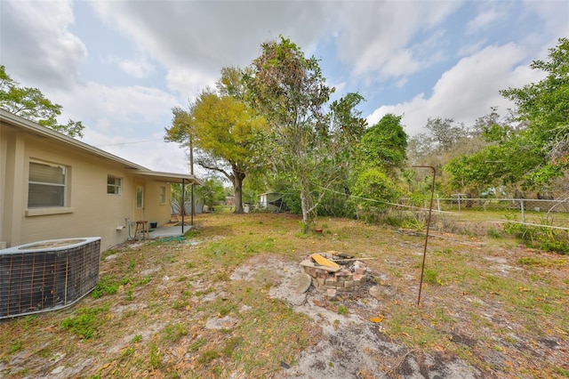 view of yard featuring a patio area, cooling unit, an outdoor fire pit, and fence