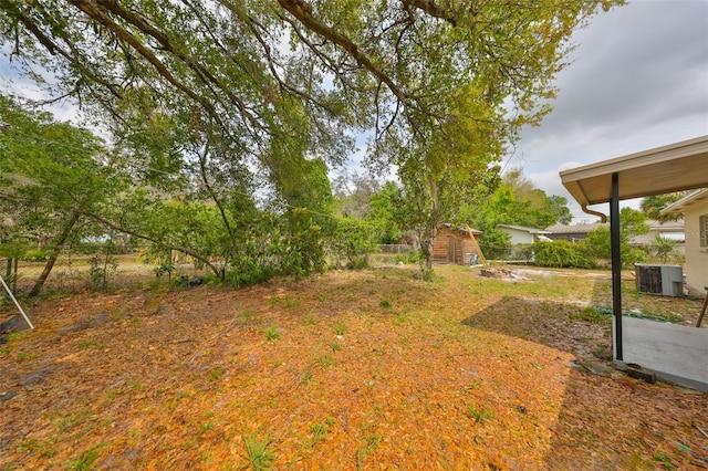 view of yard featuring central AC unit, an outdoor structure, and fence