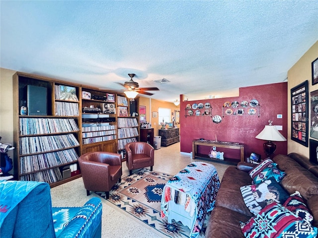 living room featuring a textured ceiling, visible vents, and a ceiling fan