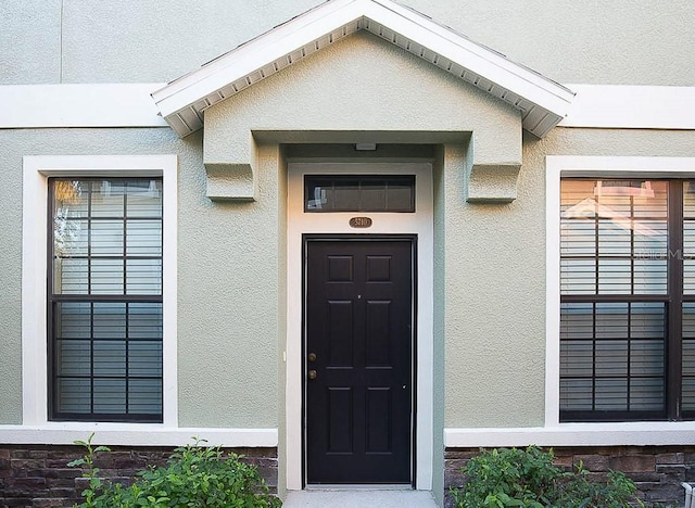 view of exterior entry featuring stucco siding