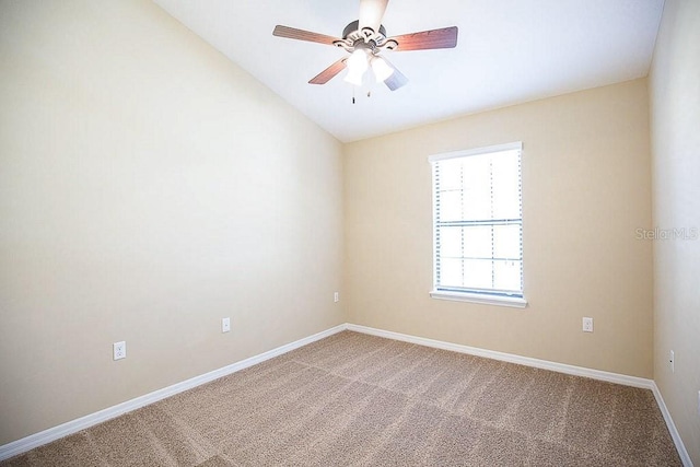 unfurnished room featuring lofted ceiling, carpet, baseboards, and a ceiling fan