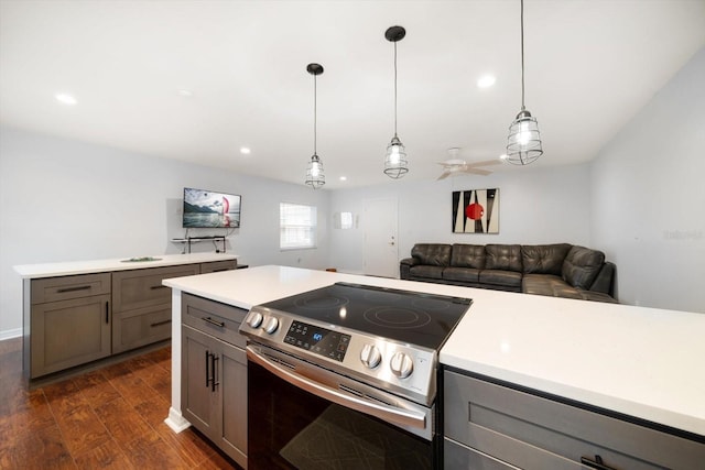 kitchen with dark wood finished floors, light countertops, hanging light fixtures, gray cabinetry, and stainless steel electric range