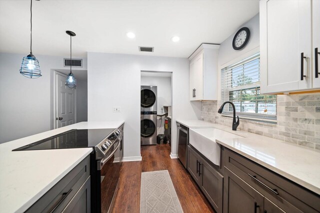 kitchen with stacked washer and dryer, visible vents, a sink, and appliances with stainless steel finishes