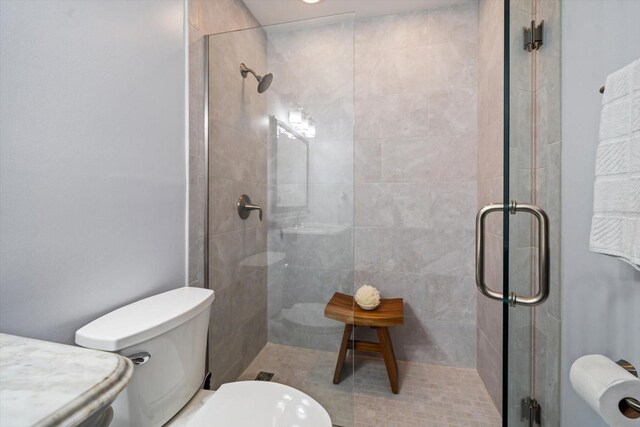 bathroom featuring a tile shower and toilet