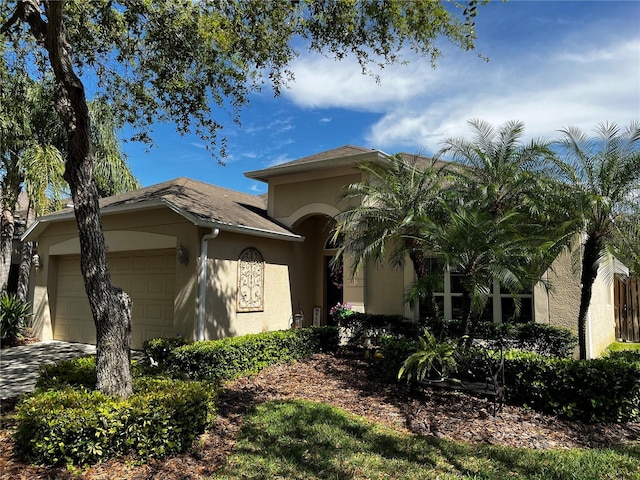 view of front of property with a garage, driveway, and stucco siding