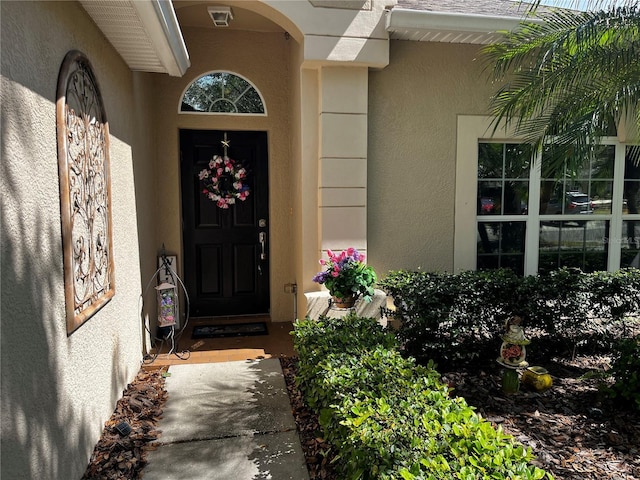 property entrance featuring visible vents and stucco siding