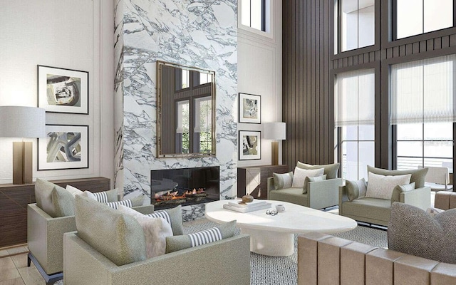 living area with a wealth of natural light, a fireplace, and a towering ceiling