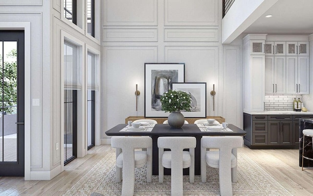 dining room with light wood finished floors and a decorative wall