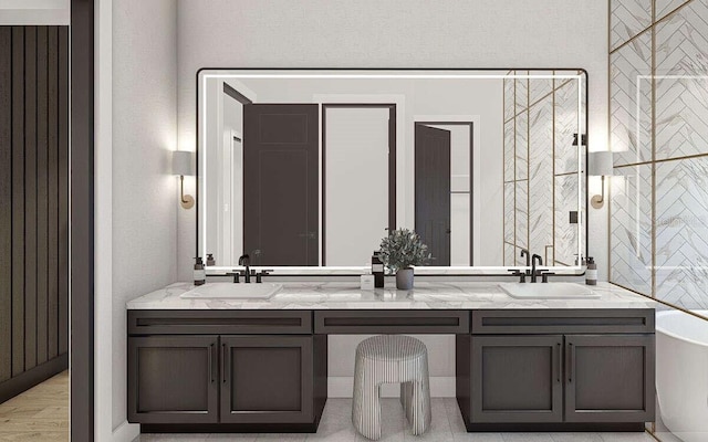 full bathroom with wood finished floors, double vanity, a freestanding tub, and a sink