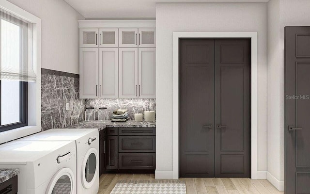 laundry room featuring cabinet space, washing machine and dryer, light wood-style floors, and a wealth of natural light