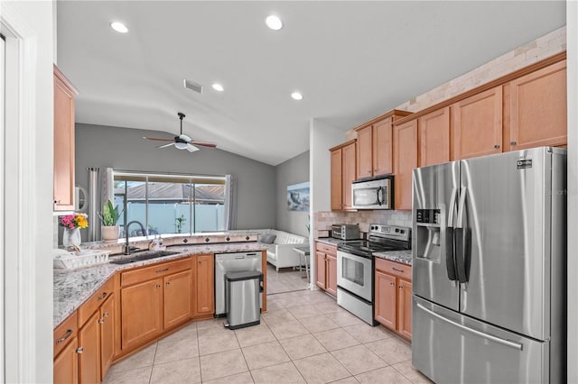 kitchen featuring lofted ceiling, visible vents, appliances with stainless steel finishes, light tile patterned flooring, and a sink