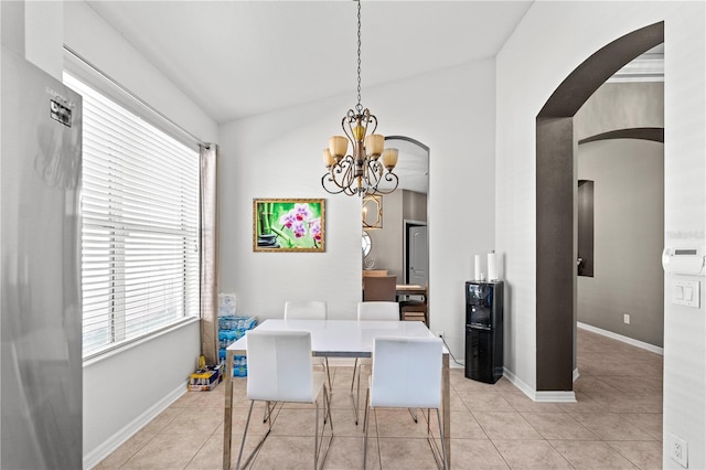 dining room with an inviting chandelier, baseboards, light tile patterned floors, and arched walkways