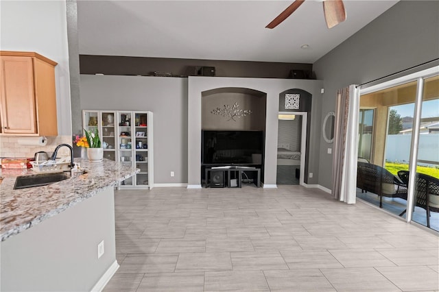 living room featuring a ceiling fan and baseboards