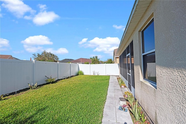 view of yard with a sunroom and a fenced backyard