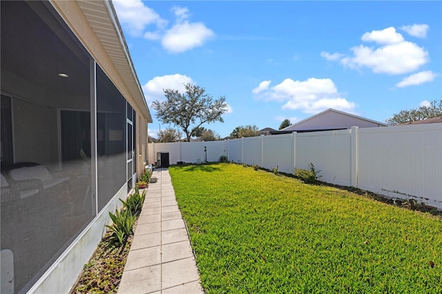 view of yard with a sunroom and a fenced backyard