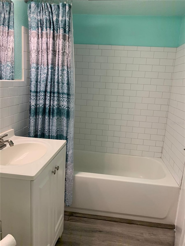 bathroom featuring shower / bath combination with curtain, vanity, wood finished floors, and tile walls