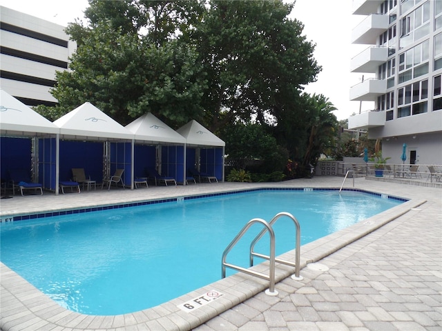 community pool with a patio and fence