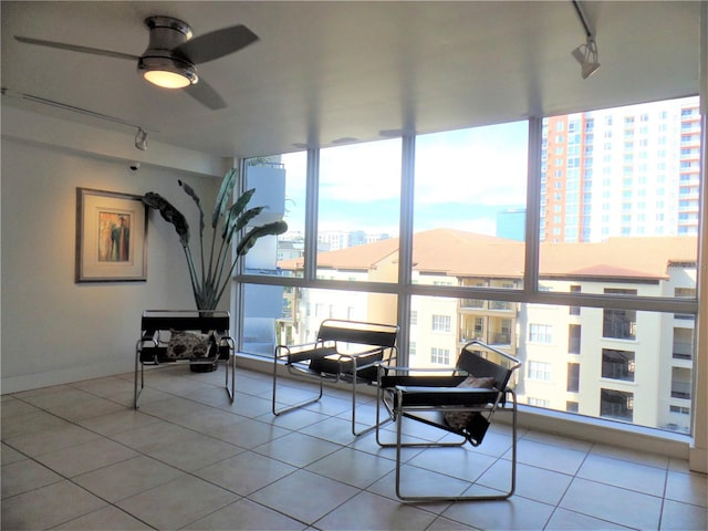 sunroom featuring a city view, a ceiling fan, and track lighting