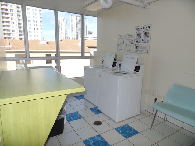 common laundry area featuring light tile patterned floors, a view of city, and washer and dryer