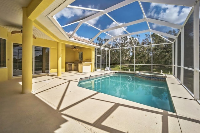 view of pool with a patio, glass enclosure, a pool with connected hot tub, and a ceiling fan