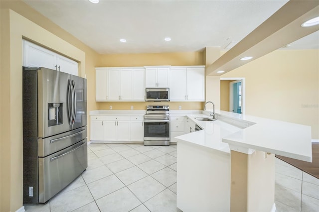 kitchen with stainless steel appliances, a sink, a peninsula, and light tile patterned floors