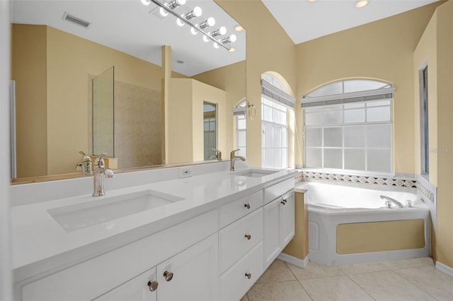 full bathroom with a bath, tile patterned flooring, visible vents, and a sink