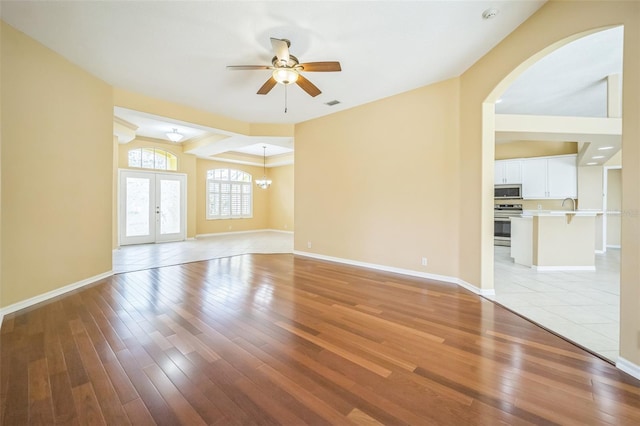 empty room with light wood-style floors, visible vents, baseboards, and french doors