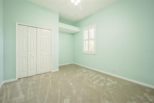 unfurnished bedroom featuring ceiling fan, a closet, carpet, and baseboards