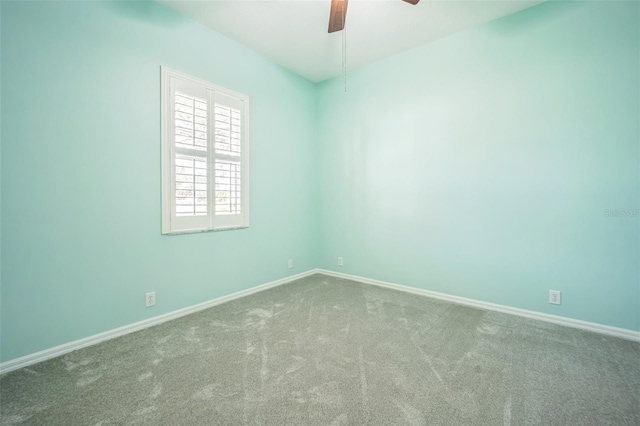 empty room featuring carpet floors, baseboards, and a ceiling fan