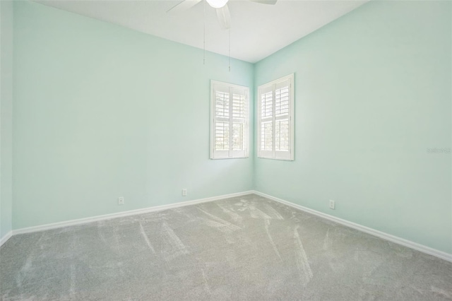 spare room with ceiling fan, carpet, and baseboards