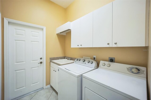 laundry room featuring washer and clothes dryer, light tile patterned flooring, a sink, and cabinet space