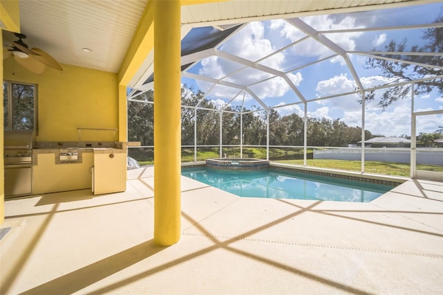 view of swimming pool featuring a pool with connected hot tub, area for grilling, a ceiling fan, a patio area, and a lanai