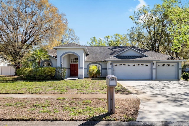 ranch-style house with driveway, a front yard, an attached garage, and stucco siding