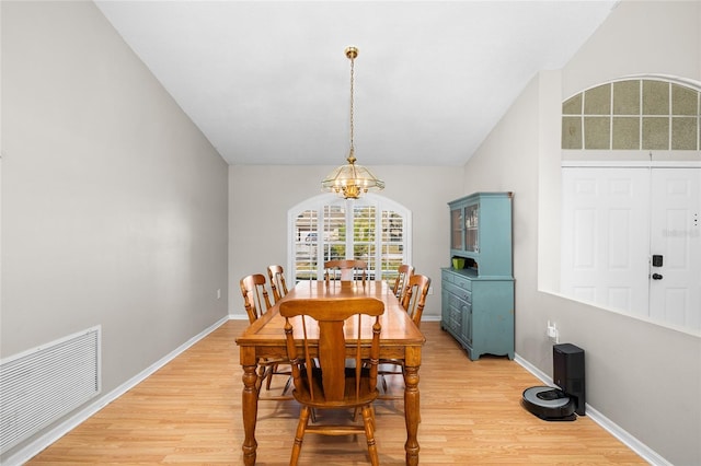 dining room featuring baseboards, light wood finished floors, visible vents, and a notable chandelier