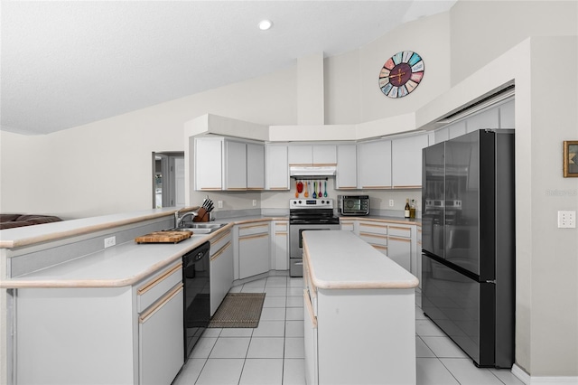 kitchen featuring light tile patterned floors, under cabinet range hood, stainless steel appliances, a sink, and light countertops