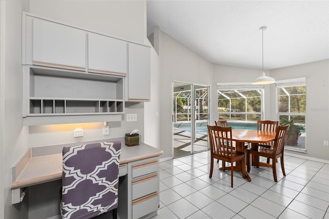 dining space featuring a sunroom, light tile patterned floors, baseboards, and vaulted ceiling