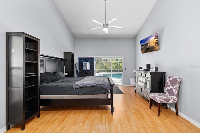 bedroom featuring light wood finished floors, access to outside, high vaulted ceiling, and baseboards