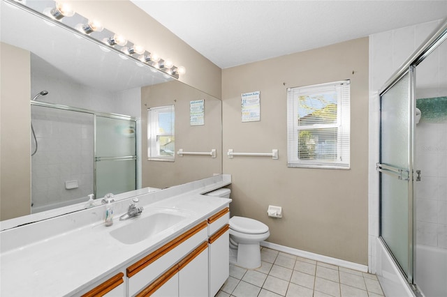 bathroom with baseboards, toilet, shower / bath combination with glass door, tile patterned flooring, and vanity