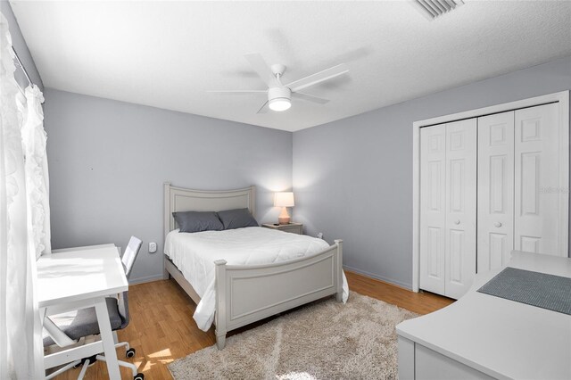 bedroom featuring ceiling fan, a closet, light wood-type flooring, and visible vents