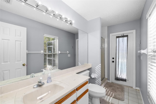 bathroom featuring a stall shower, tile patterned flooring, vanity, and toilet