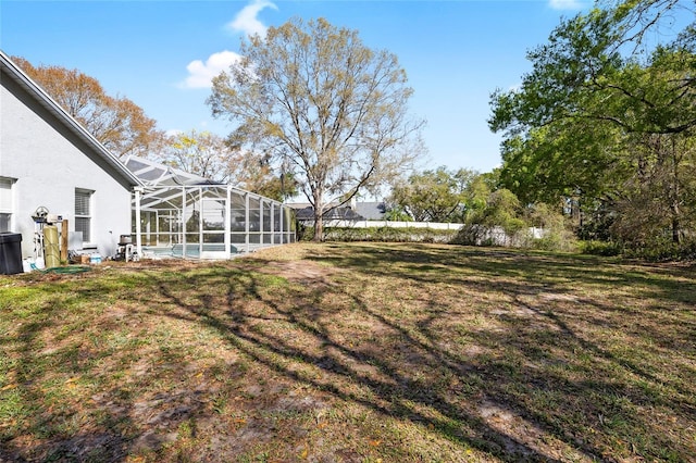 view of yard with a lanai and a swimming pool