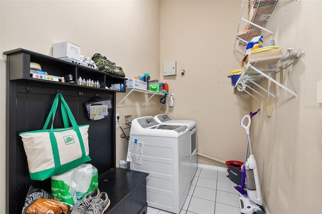 washroom with laundry area, tile patterned flooring, washing machine and dryer, and baseboards