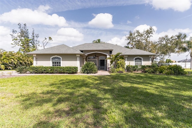 ranch-style house featuring a front yard, a ceiling fan, and stucco siding